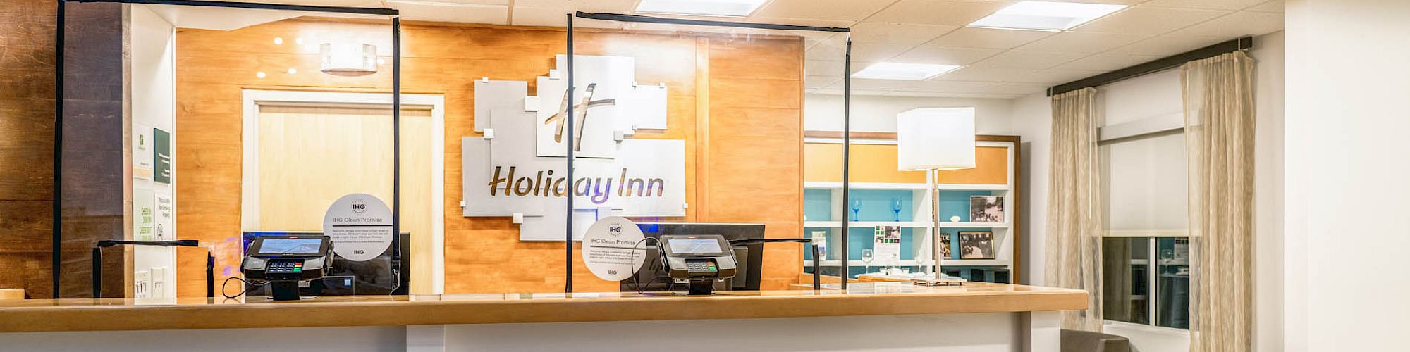 The image shows a hotel reception desk with the 