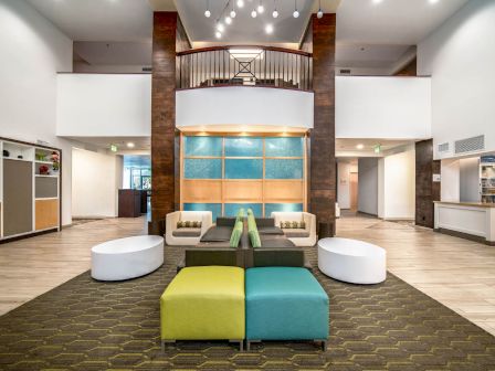 This image shows a modern hotel lobby with seating, decorative elements, and a bright, welcoming atmosphere.